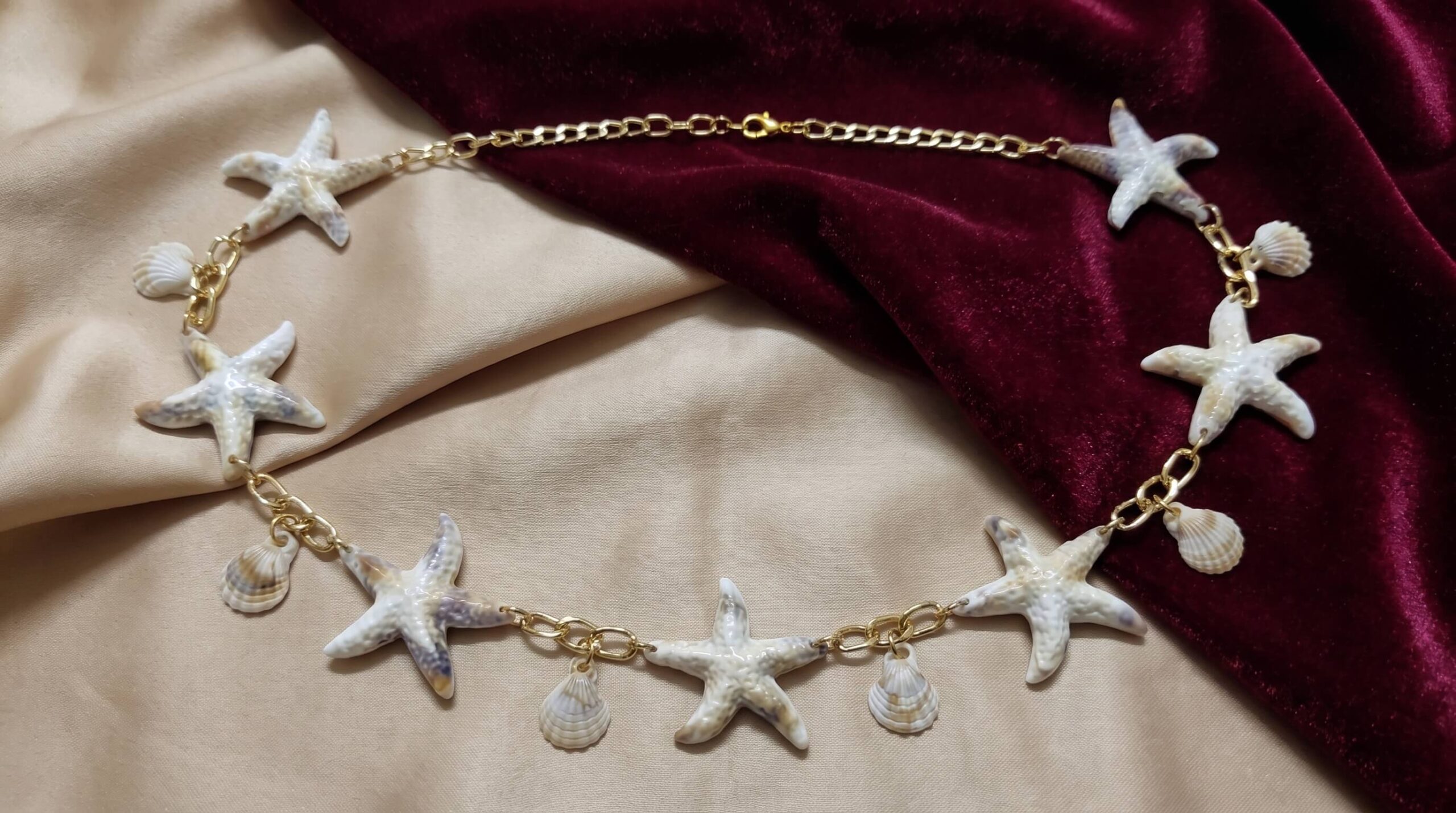 حزام خصر حريمي ذهبي بنجوم البحر والصدف على خلفية بيج ونبيتي | Women's gold-tone starfish and shell waist belt